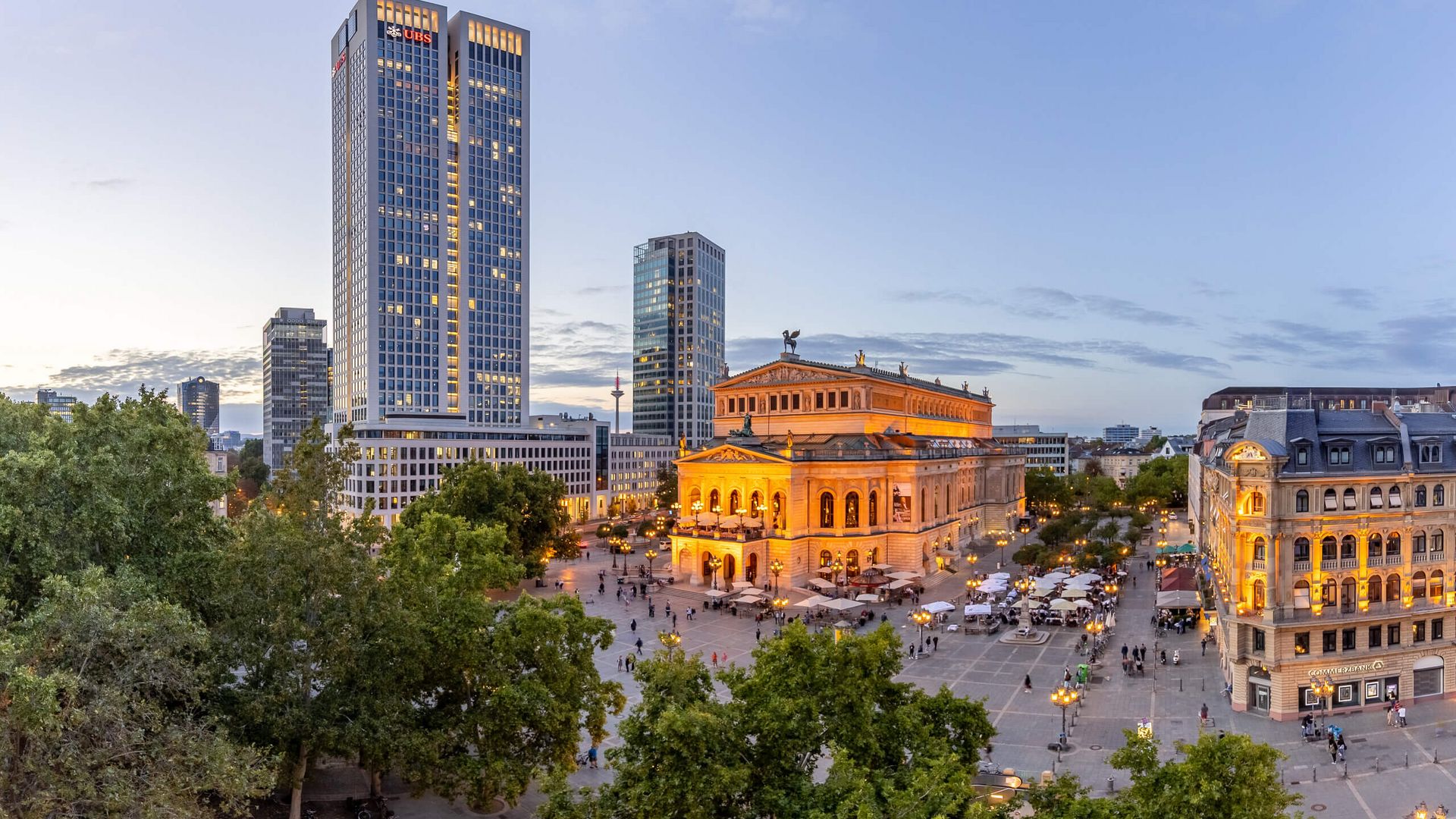 Panoramabild mit Alter Oper, Hochhaus und schönen Altbauten in Abendstimmung.
