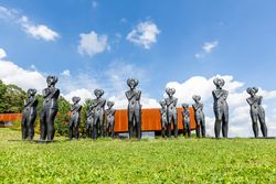 Reihe von Keltenfiguren vor moderner Keltenwelt-Architektur