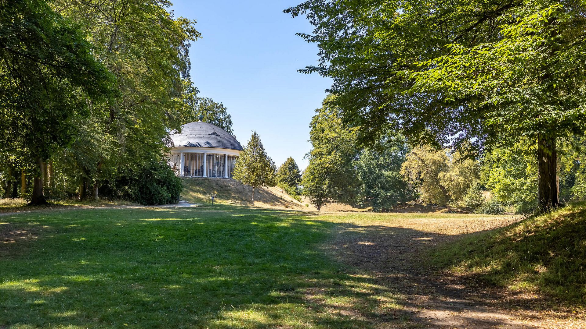 Historisches Karussell im Park Wilhelmsbad zwischen Bäumen