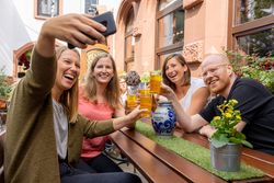 Menschen im typischen Apfelweinrestaurant essen und haben Spaß, prosten sich mit Apfelwein im Gerippten zu.