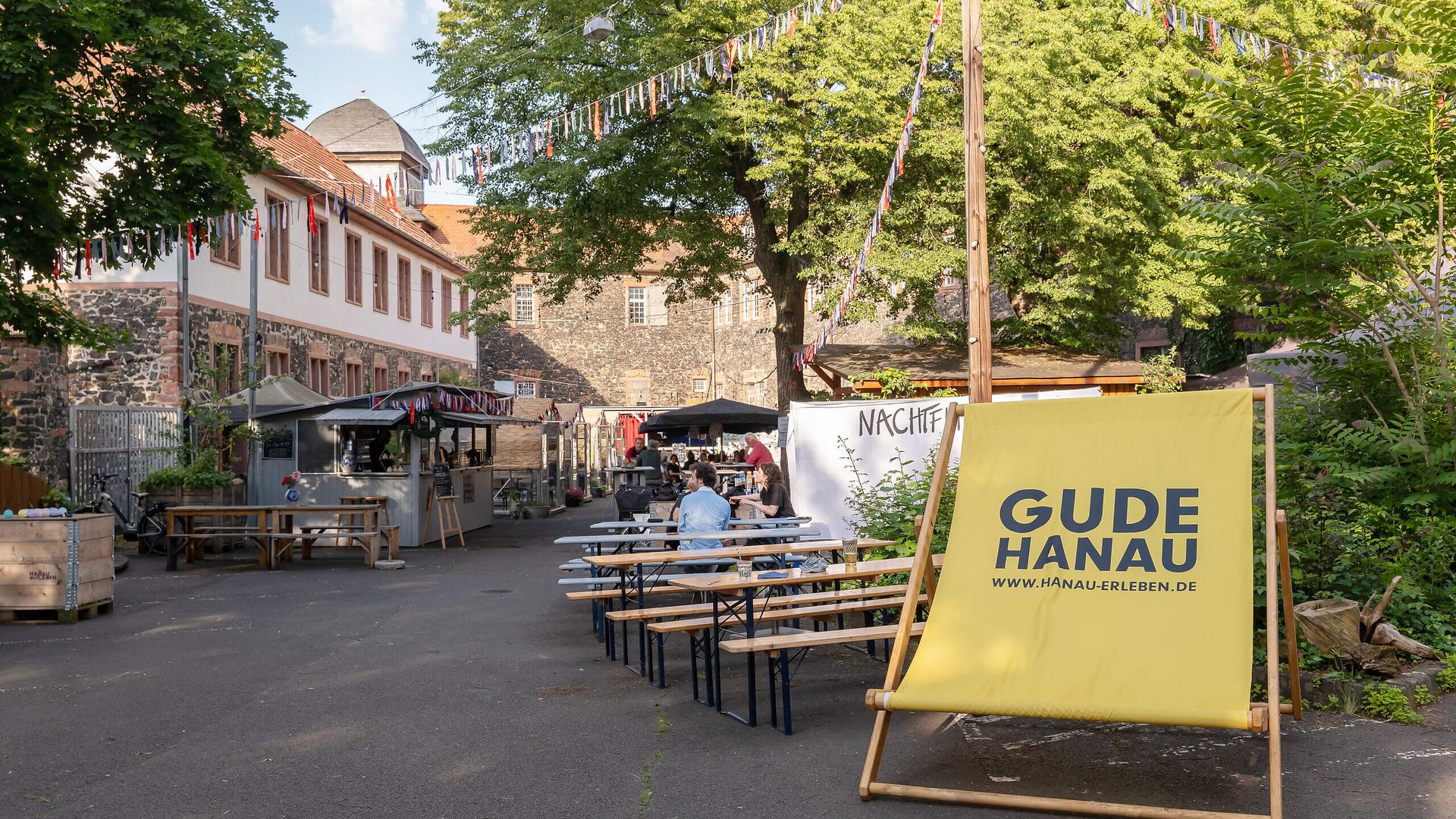 Biergarten der Wirtschaft im Hof mit Sitzbänken und sommerlicher Atmosphäre