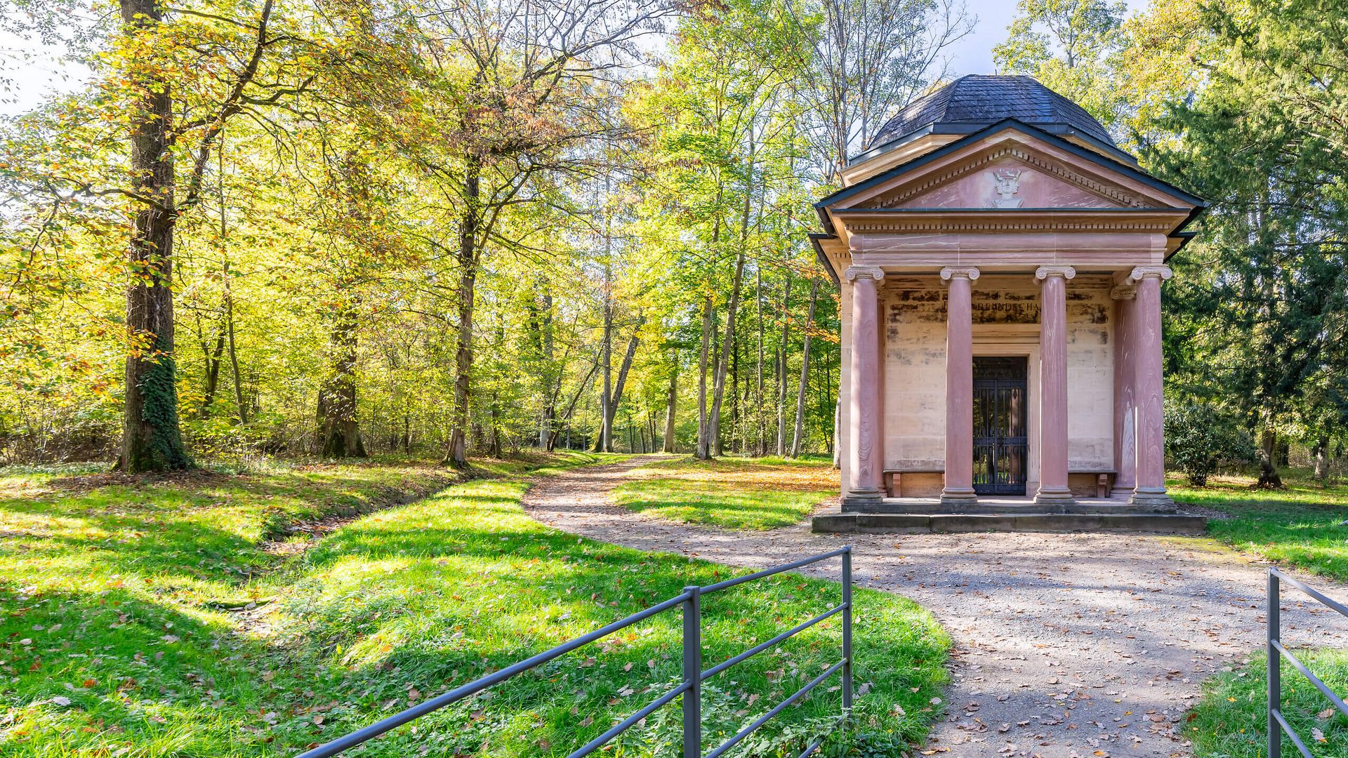 Kleiner klassizistischer Pavillon im Park Schönbusch umgeben von Bäumen.