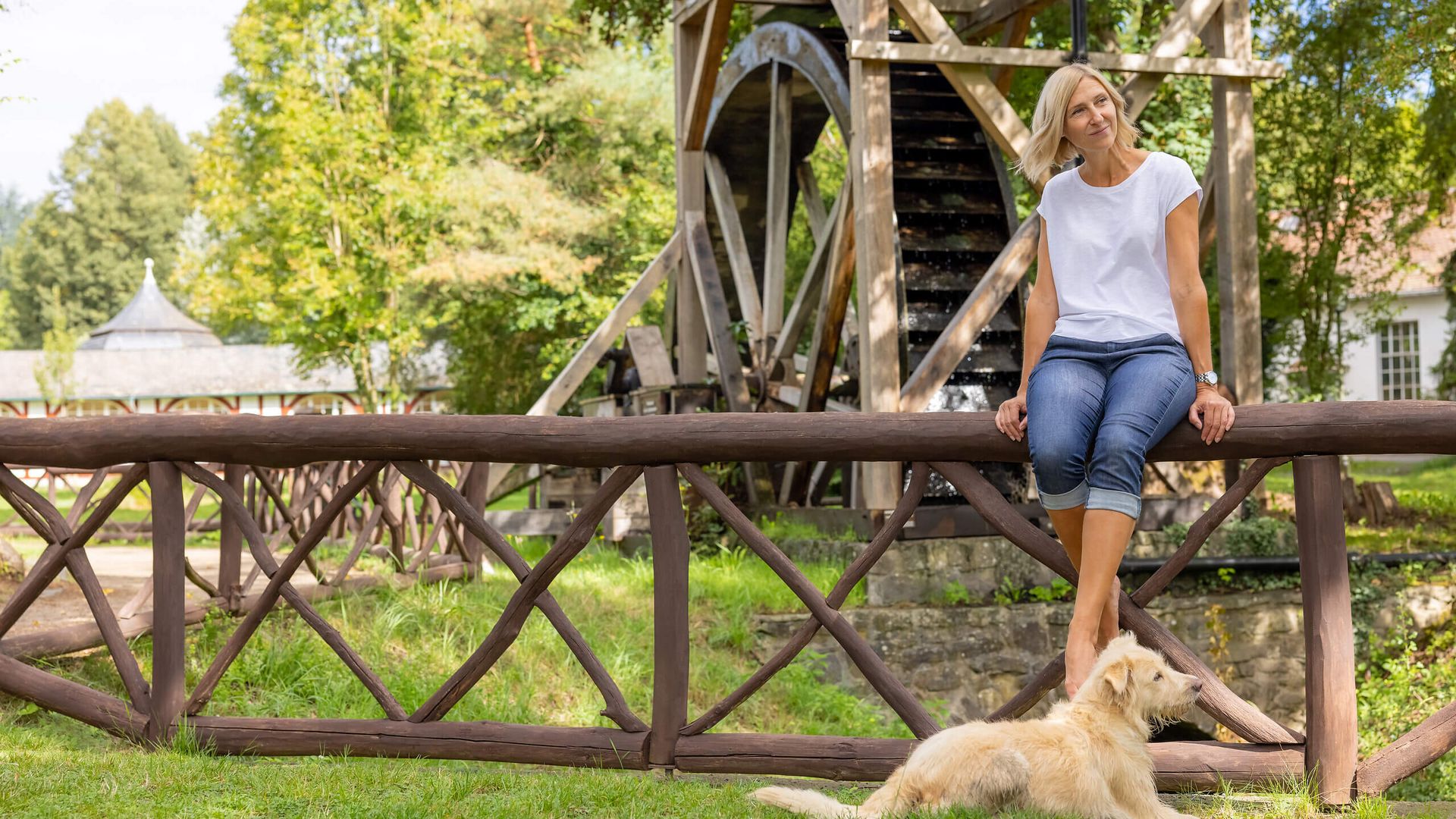 Frau mit Hund am Wasserrad im Kurpark Bad Salzhausen