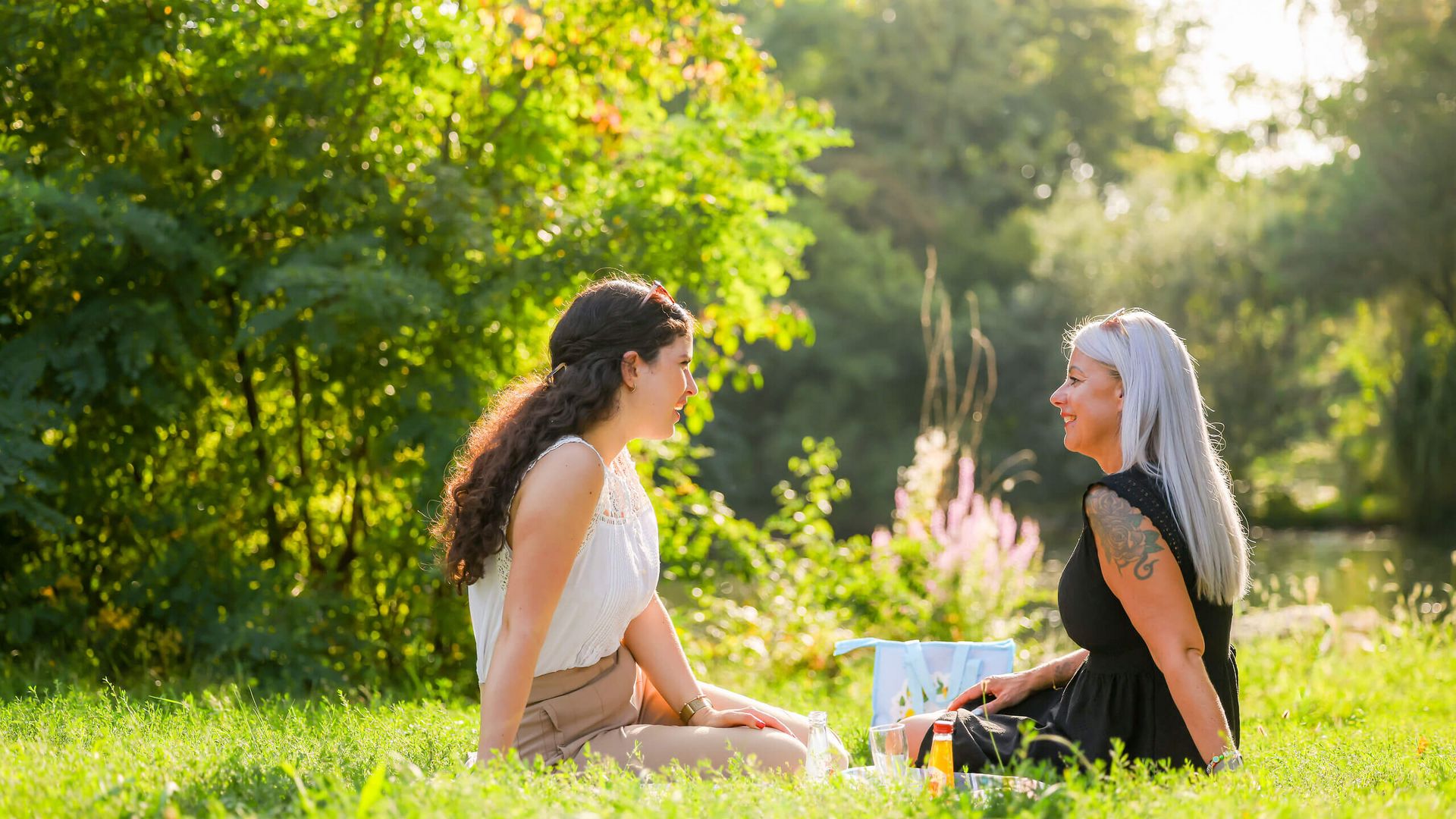 Zwei Frauen unterhalten sich entspannt bei einem Picknick im Südpark Kelsterbach.
