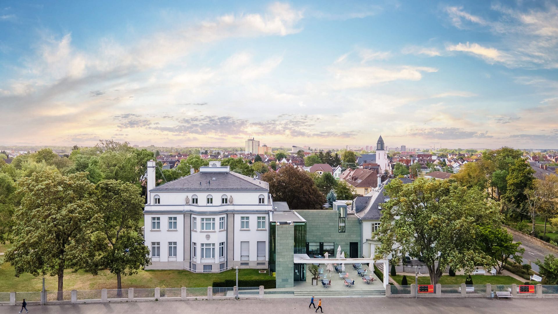 Luftaufnahme der Opelvillen in Rüsselsheim mit Blick auf den Park und die Stadt im Hintergrund.