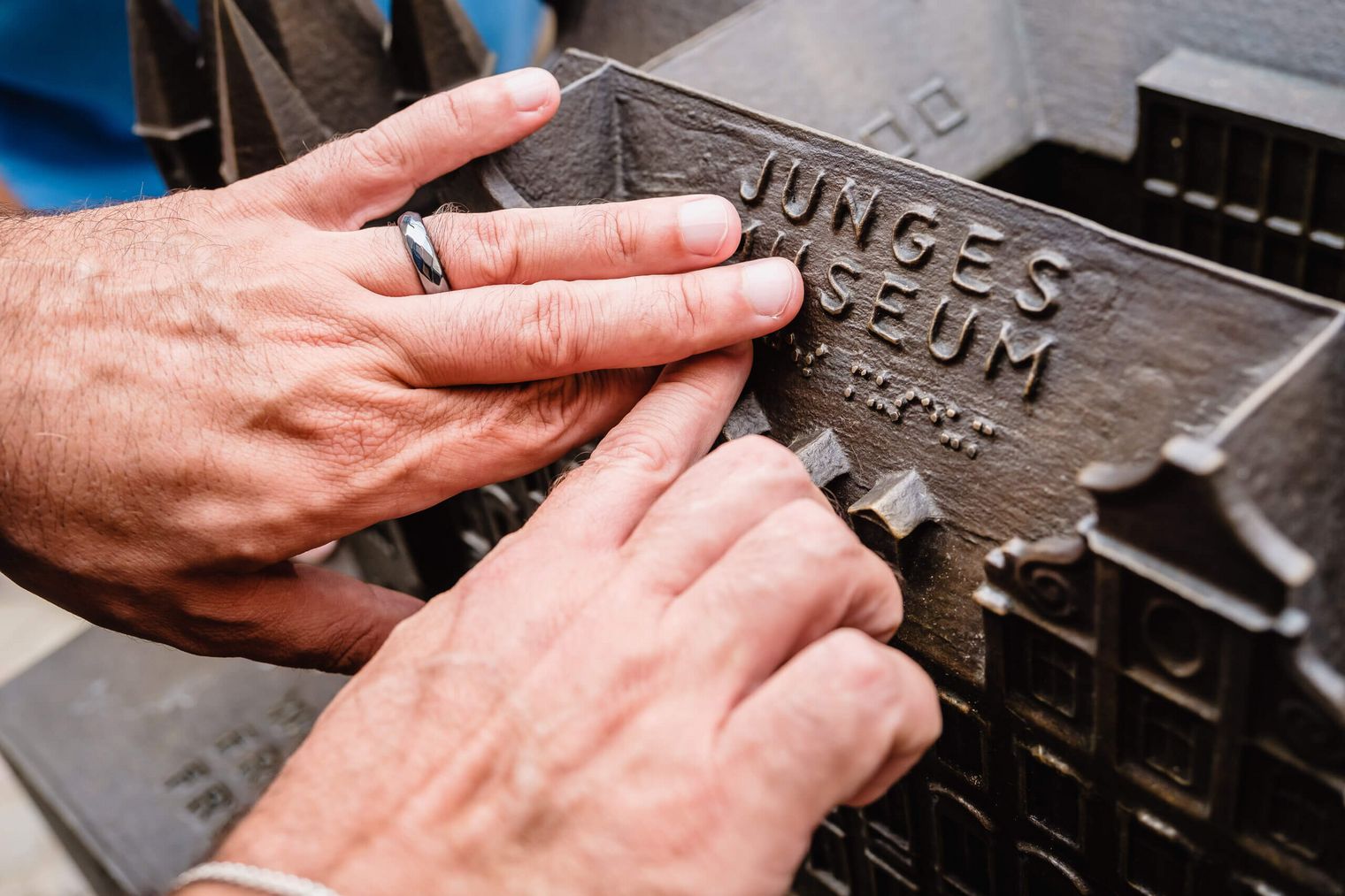 Hände fahren über die Braille Schrift am Modell des Historischen Museums